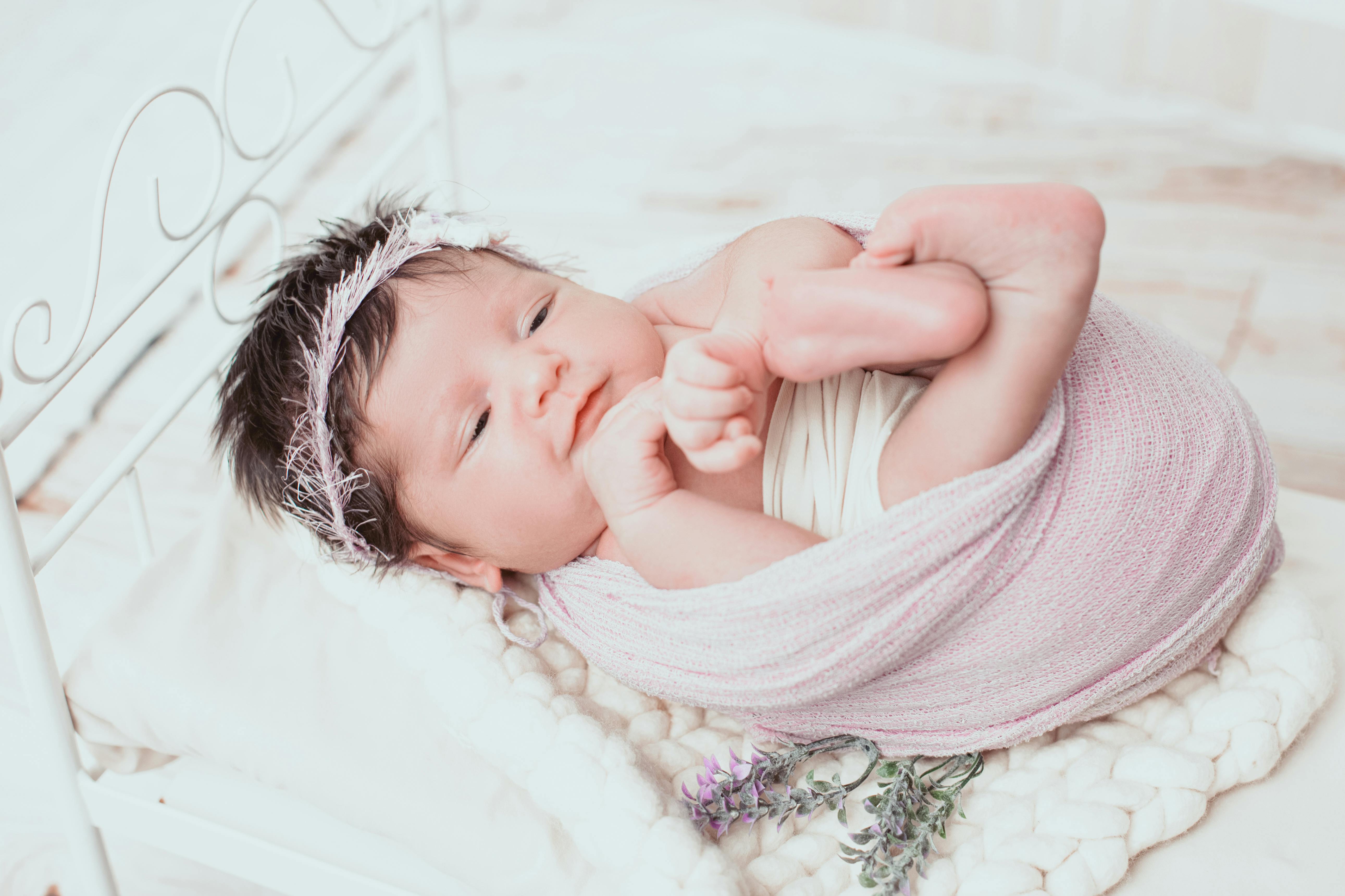 Newborn baby photoshoot with soft lighting and cozy setup