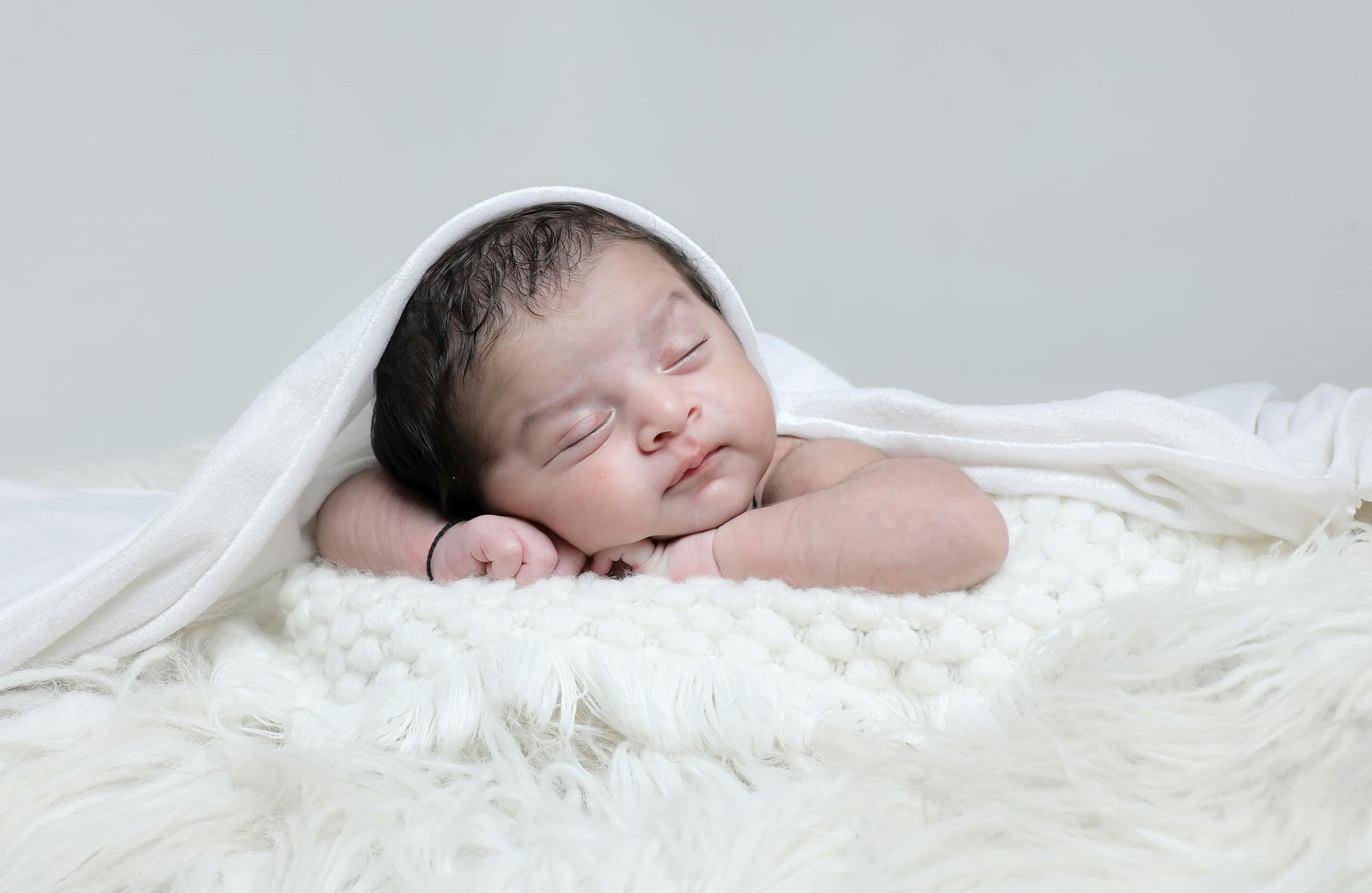 Professional newborn photography with cute baby pose